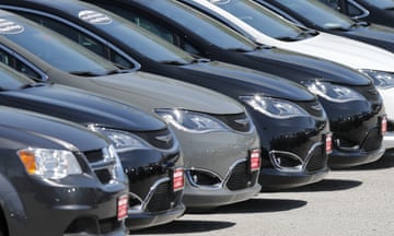 A closeup of a row of cars in a sunny parking lot.