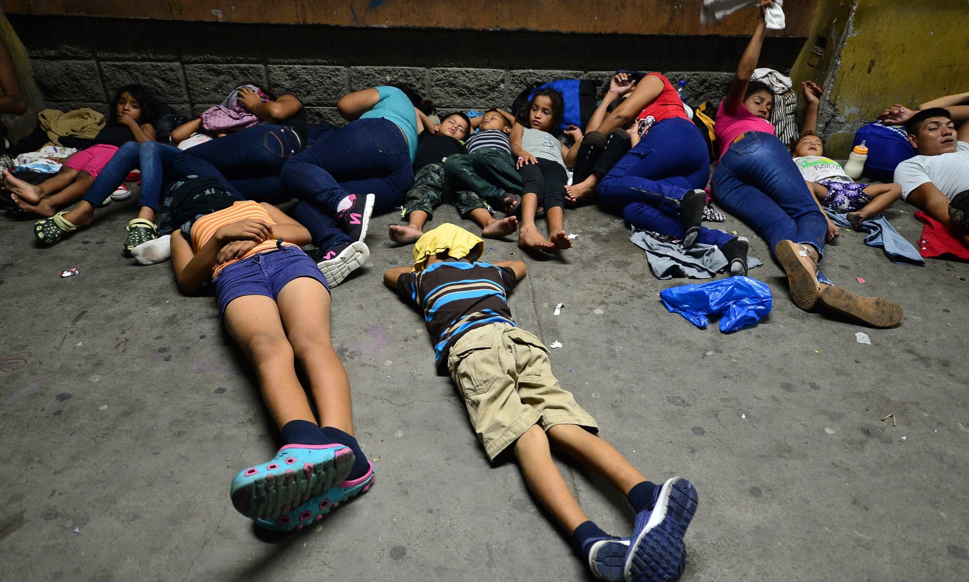 Honduran families sleep in the streets waiting to board a bus leaving the Metropolitan Center of San Pedro Sula, 300 kms north of Tegucigalpa, to travel to the Guatemala border on 9 April 2019.