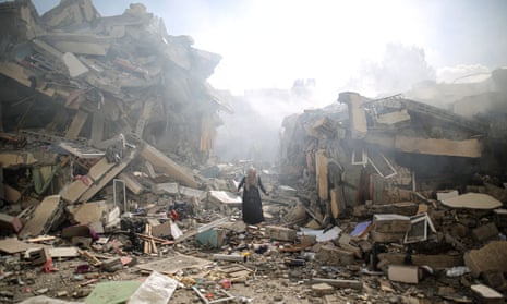 A resident of Gaza City amid the rubble of residential buildings after Israeli airstrikes.
