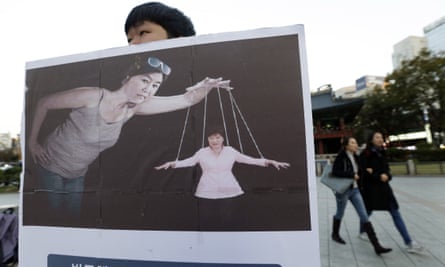 A student holds a placard depicting South Korea’s president, Park Geun-hye, as a puppet manipulated by Choi Soon-sil.