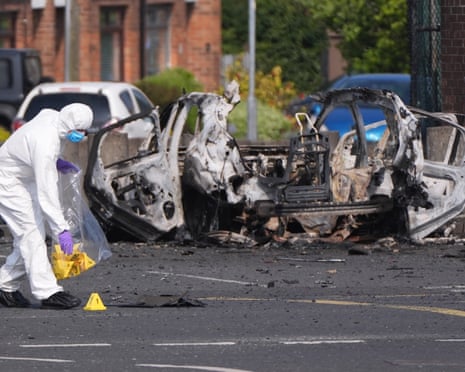Indagini della polizia sulla scena dell'autobomba all'esterno Stazione di polizia di Belfast