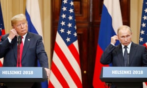 The US president, Donald Trump, and the Russian president, Vladimir Putin, adjust their earpieces during a joint press conference following their summit talks in Helsinki