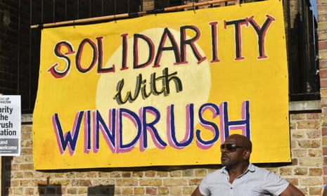 Man with Windrush poster