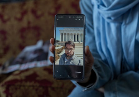 An image of a man on a phone being held by a woman