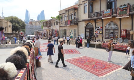 Carpets on the ground and hanging as people mill around