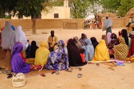 Women gather below a neem tree in a village outside of Dongondoutchi to hear Moundadou Magagi, a health agent with PSI, explain family planning options