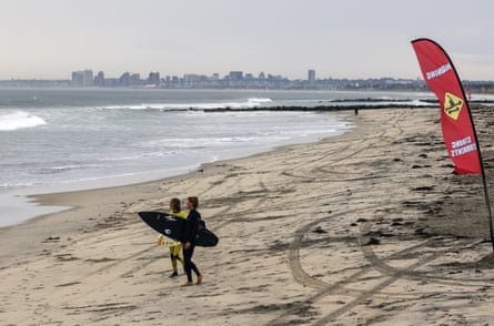 Surfers head out to waves in Imperial Beach, California, where researchers monitored the air and water after storms.
