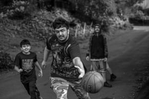 Saleh reaches for the basketball as his brother and friend watch