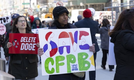 People hold signs that read 'delete doge' and 'save CFPB'