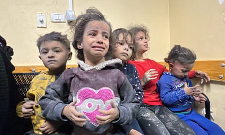 Five Palestinian children sit on a bench in the hospital