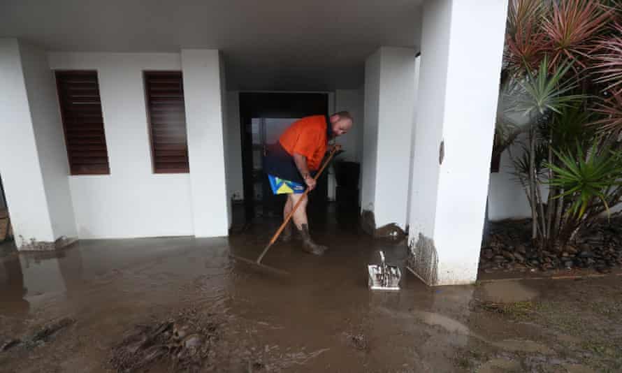 Un résident commence à nettoyer après les dommages causés par les inondations à Port Macquarie.