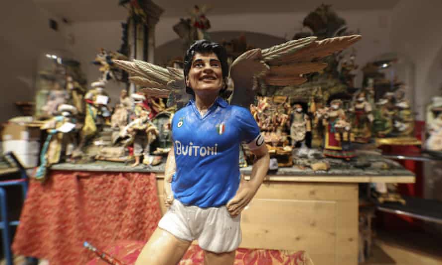 A statuette by artist Genny Di Virgilio portraying Diego Maradona with angel’s wings next to a nativity scene in his shop in Naples, Italy.