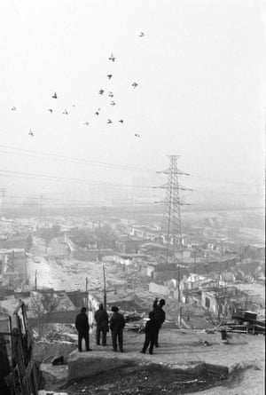 Black and white image of people looking out over an urban landscape