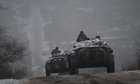 Ukrainian personnel drive military vehicles along an icy road in the Donetsk region.