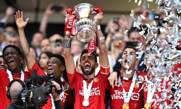 Manchester United captain Bruno Fernandes lifts the FA Cup Trophy after his team's victory over Manchester City.
