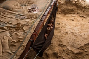 A child sleeps inside a homemade hammock at the al-Manjora camp for Yemeni refugees