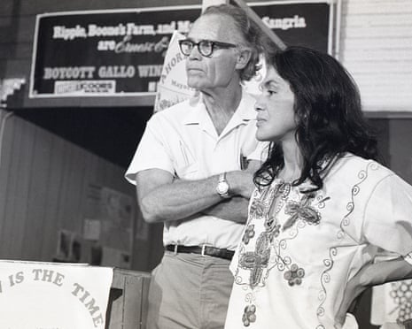 Black and white image of tall man in glasses and woman in peasant shirt looking in the same direction.