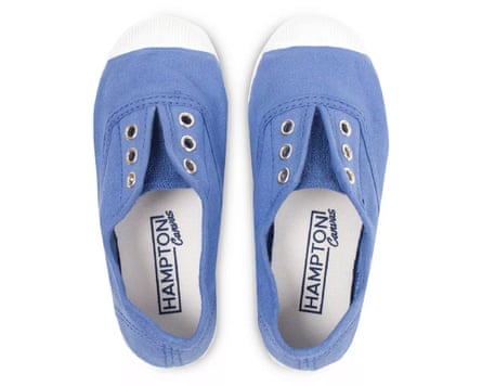 A birds eye view of a pair of cornflour blue plimsole shoes with eyelets, no laces and white rubber toe caps
