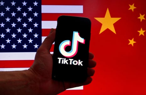 In this photo illustration the social media application logo for TikTok is displayed on the screen of an iPhone in front of a US flag and Chinese flag background in Washington, DC, on March 16, 2023.