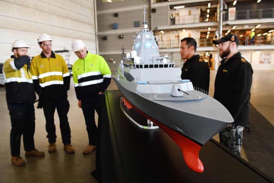 ASC workers and navy personnel look at a model of a Hunter class frigate in Adelaide in June 2018.