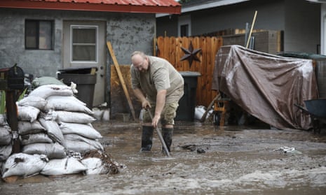 A resident shovels back floodwater as monsoon rains fell on the Museum Fire burn area causing flooding from the Paradise Wash in east Flagstaff, Ariz. on Wednesday, July 14, 2021. The threat of flash flooding will remain through next week, the National Weather Service said, though the coverage will be more scattered than widespread. (Jake Bacon/Arizona Daily Sun via AP)