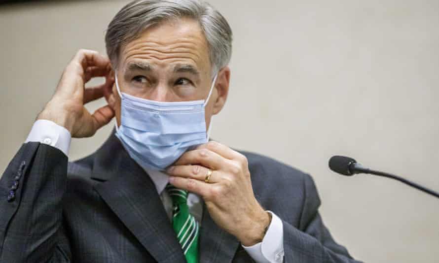 Greg Abbott adjusts his mask after giving an update on 16 June 2020, in Houston.