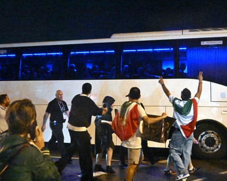 People cheer the Iranian women’s football team on their bus after their defeat to the Philippines on Sunday night.