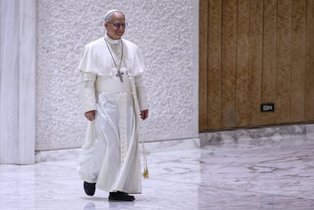 a man in white robes with a cross walking