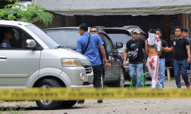 Indonesian police officers accompany the suspect in Medan.