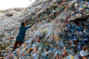 Um trabalhador classifica garrafas de plástico em um centro de reciclagem nos arredores de Wuhan, província de Hubei, na China