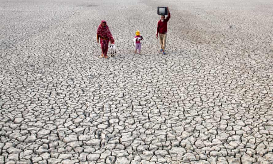 Villagers in Bangladesh walk on a dry river bed.