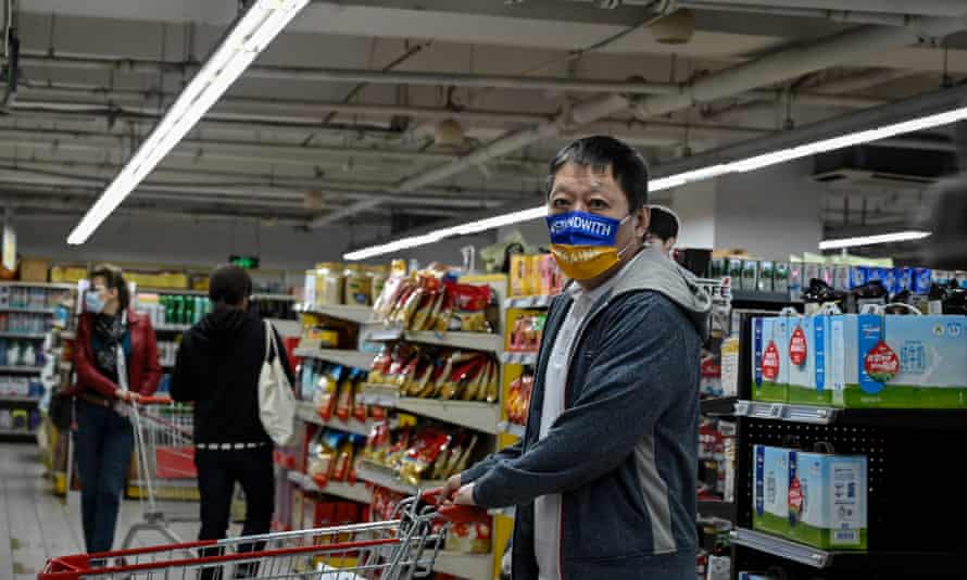 A man wearing a mask which reads Stand With Ukraine browses through food at a supermarket in Beijing on April 13, 2022.