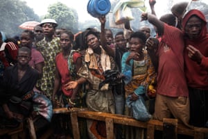 Internally displaced people queue for food holding buckets and basins in the CAR capital
