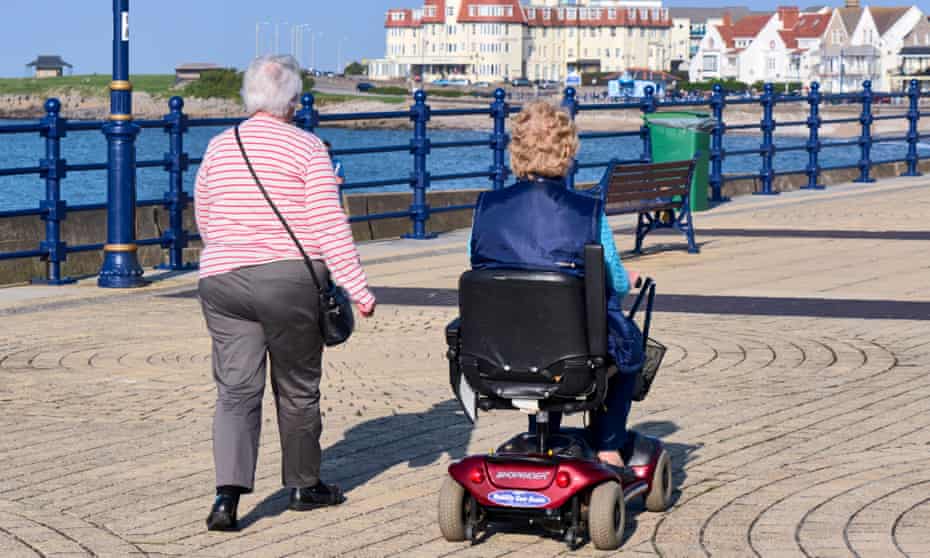 Elderly residents walk on the seafront in Porthcawl, south Wales