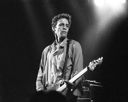 Black-and-white photo of a man playing guitar on stage