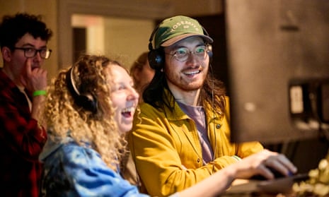 a woman and a man smiling and laughing as they play a video game (out of shot)