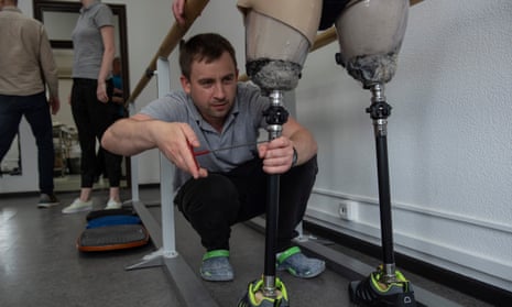 A specialist adjusts a patient's prosthetics.