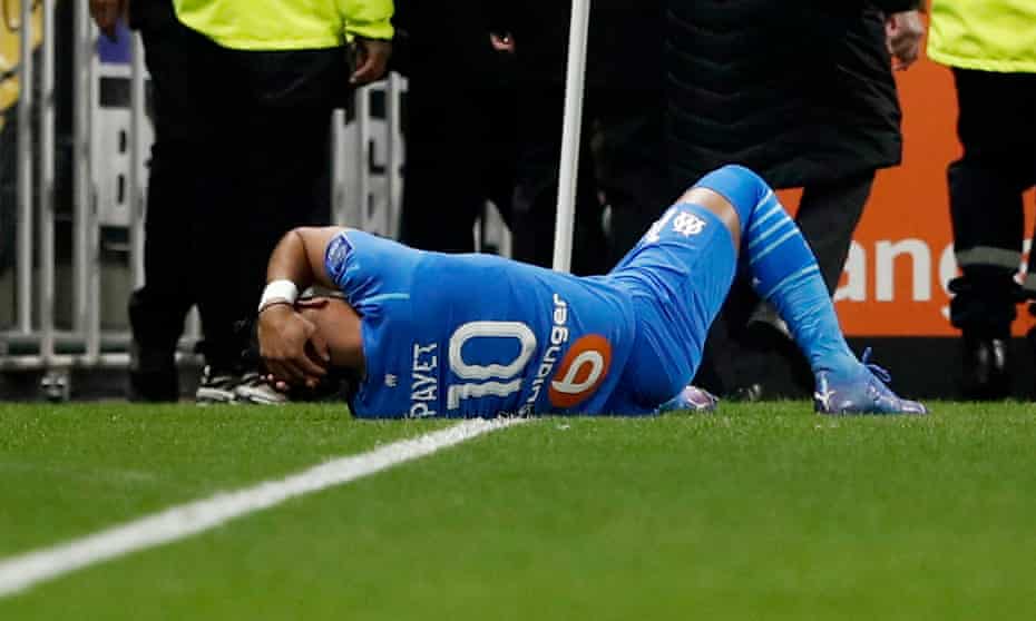 Marseille's Dimitri Payet clutches his head after being hit by a water bottle thrown by a Lyon fan.