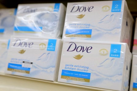 Packaged bars of Dove soap on a shop shelf with the logo clearly displayed.
