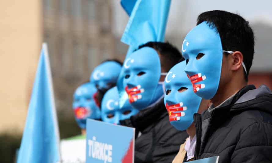 Uighur protesters in Istanbul, Turkey, hold Uighur flags and placards at a protest against China.