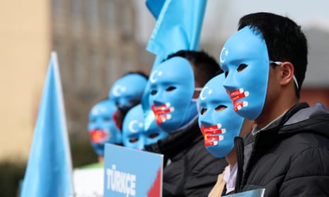 Uighur protesters in Istanbul, Turkey, hold Uighur flags and placards at a protest against China.