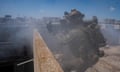 An IDF soldier aims a shoulder-mounted weapon on a rooftop in Rafah