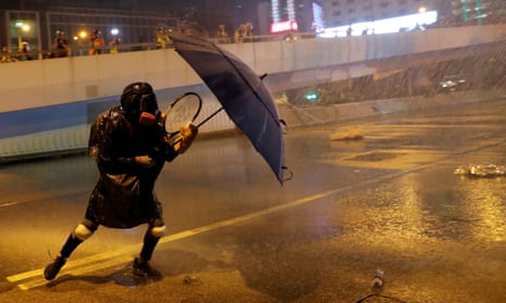 An anti-government protester protects himself from police spray outside the government buildings in Hong Kong.