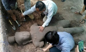 Archaeologists excavate a statue believed to have once stood guard over an ancient hospital at Cambodia’s famed Angkor temple complex.