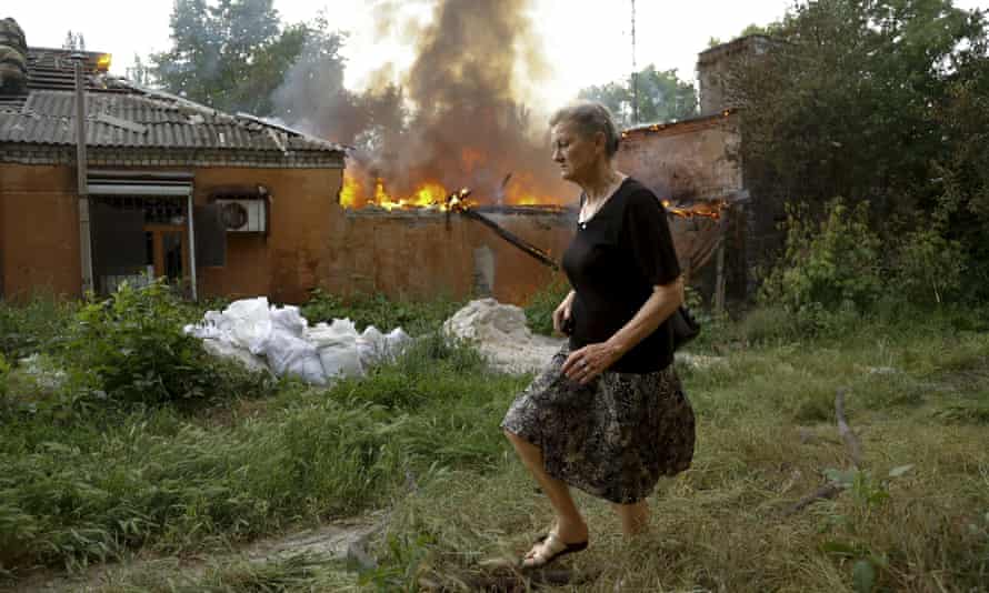 A woman runs from a house on fire after shelling in Donetsk, eastern Ukraine.
