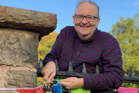 David Greenhalgh smiling and holding some bunting