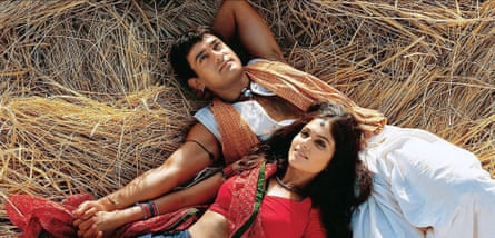An Indian couple lying on hay dressed in traditional costume