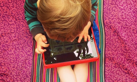 A young boy playing on a tablet.