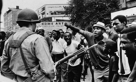 A man gestures with his thumb down to an armed National Guardman, during a protest in the Newark race riots, Newark, New Jersey, 1967.
