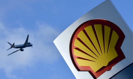 Passenger plane flies over a Shell logo at a petrol station in west London